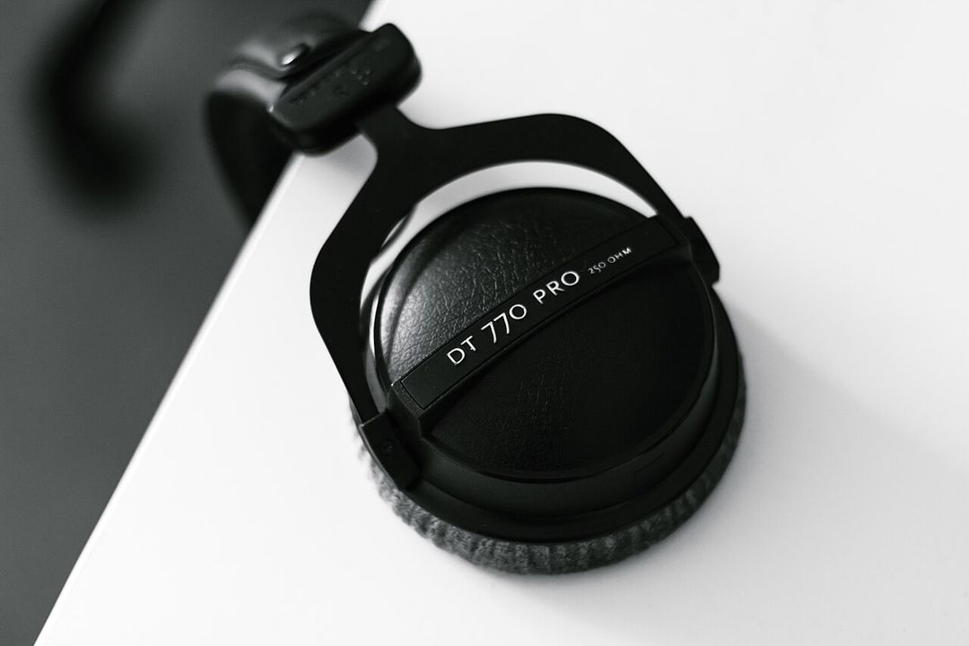 Casque audio suspendu au bord d'un bureau, vu de dessus.