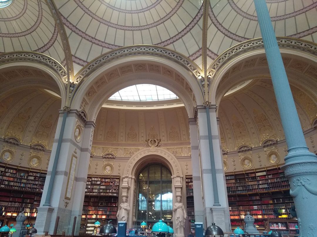 La salle Labrouste de la Bibliothèque nationale de France, site Richelieu, avec ses coupoles et ses rayonnages de livres.