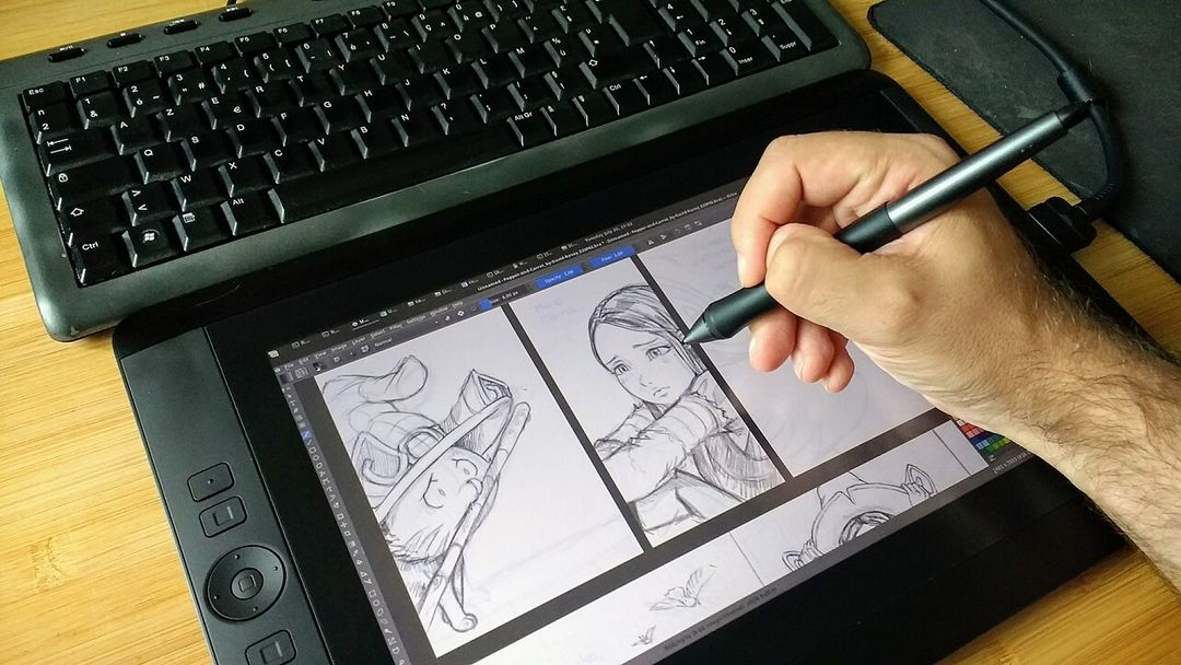 Un illustrateur crayonne une planche de bande dessinée sur une tablette graphique à écran.