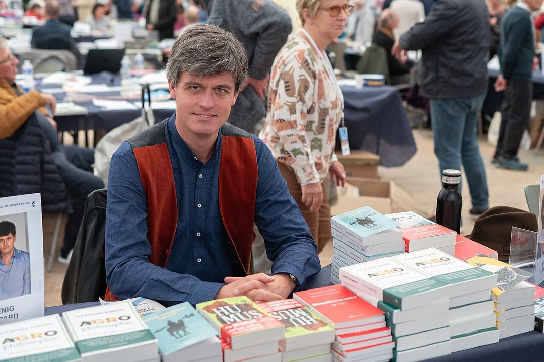 L'écrivain Gaspard Koenig assis à une table lors d'une rencontre publique.