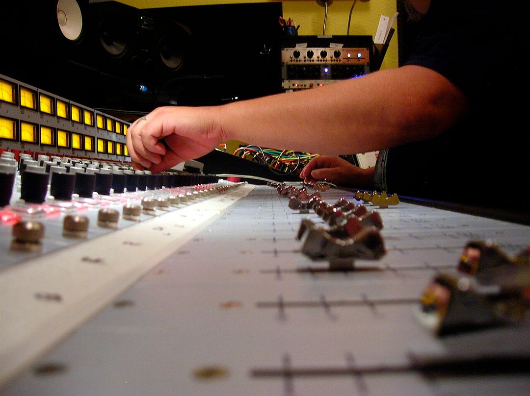 Un ingénieur du son mixe un morceau sur une console analogique dans un studio d'enregistrement.