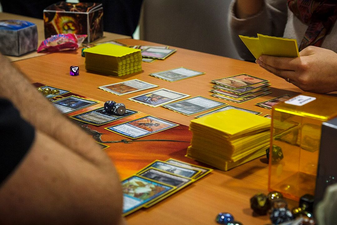 Partie de Magic: The Gathering en cours, cartes étalées sur une table.