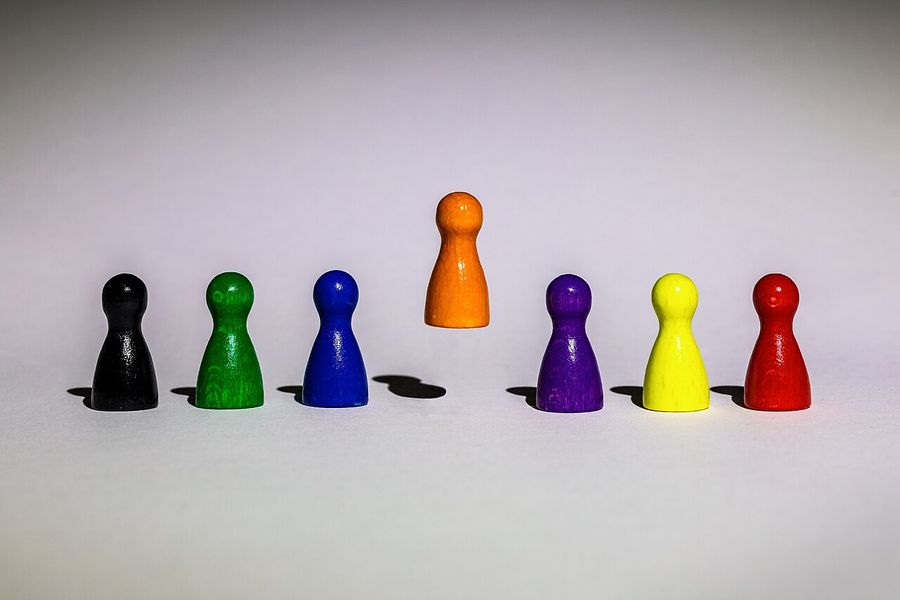 Sept pions de jeu de couleurs alignés, le pion orange semblant flotter au-dessus des autres.