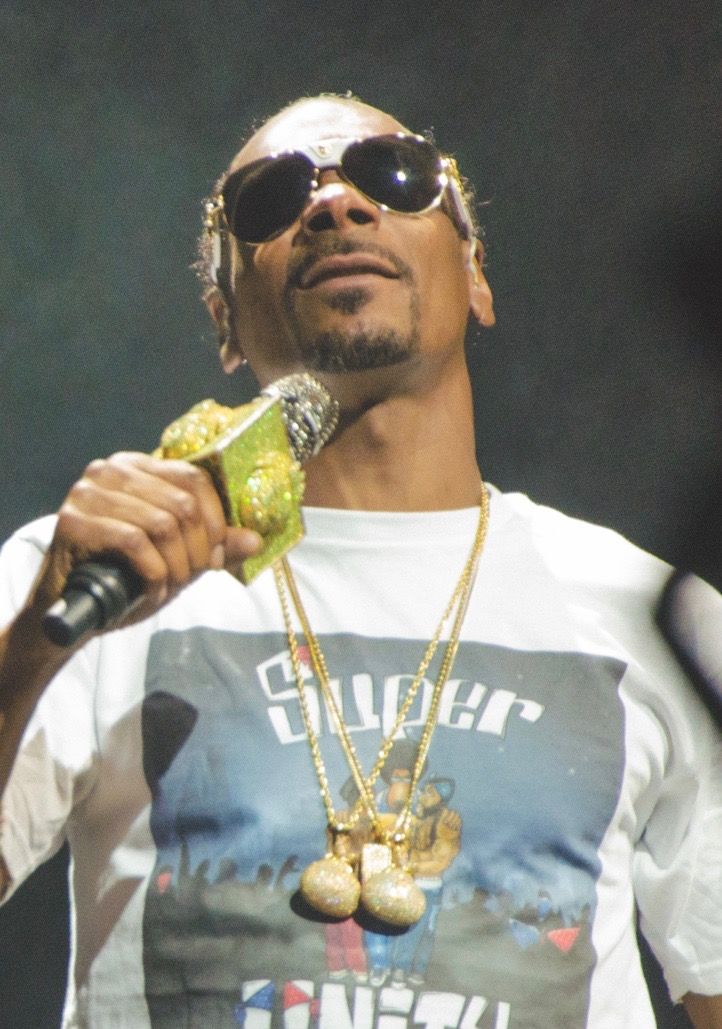 Snoop Dogg sur scène en concert, micro à la main.