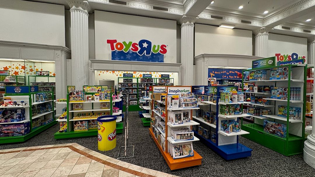 Rayon Toys R Us avec son enseigne colorée dans un grand magasin.